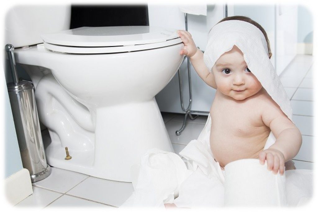 Toddler ripping up toilet paper in bathroom